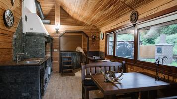 Un intérieur en bois avec un évier en pierre, un banc et une table à manger.