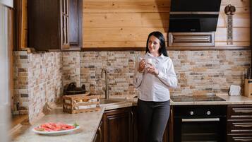 Ett kök med träskåp, en diskmaskin från Bosch och en stänkskydd av sten.