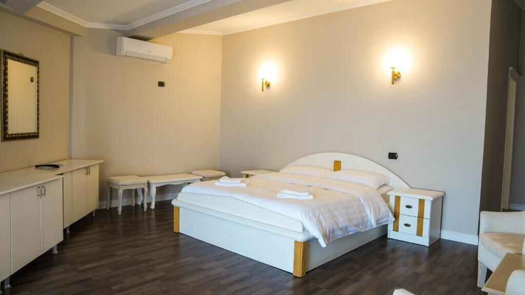 Un dormitorio con una cama grande, mesitas de noche, un escritorio y una silla.