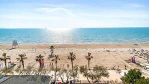 A beach with palm trees, a sandy shore, and a clear blue sky. - Hotel Majestic (Durrës)