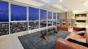 A modern living room with a large city view through floor-to-ceiling windows, a glass coffee table, and a leather sofa. - Tower Sea View Luxury 32 Floor Apartment (Tel Aviv)