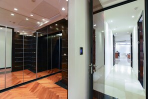 Een modern interieur met een houten vloer, glazen wanden en een gang naar een receptie.