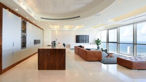 A modern kitchen with built-in appliances, a large island, and a dining area with a view of the ocean. - Tower Sea View Luxury 32 Floor Apartment (Tel Aviv)