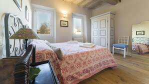 A bedroom with a bed, bedside table, lamp, and a window. - A delightful apartment for 5 people in the heart of San Frediano and close to Piazza S. Spirito (FIrenze)
