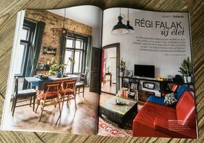 Cozy living and dining spaces with a stylish table, chairs, sofa, and bookshelf.