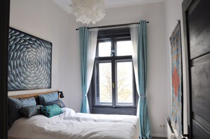 Enjoy a restful night's sleep in this cozy space with a large bed and modern lighting.