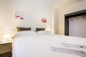 A neatly made bed with white linens, a bedside lamp, and two wall-mounted pictures. - Perlasca house UP Cernobbio (Cernobbio)