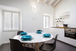 A modern kitchen with white cabinets, a built-in oven, and a countertop with a coffee maker. - Perlasca house UP Cernobbio (Cernobbio)