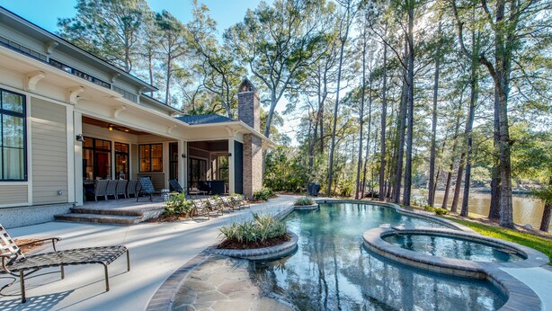 A house with a swimming pool, outdoor seating, and a forested area. - 85 Mooring Buoy -Dock, Private Pool & Lagoon Views. 176 Yards to the ocean (Hilton Head Island)