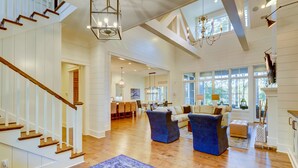 A spacious living area with a wooden staircase, a dining area, and a kitchen. - 85 Mooring Buoy -Dock, Private Pool & Lagoon Views. 176 Yards to the ocean (Hilton Head Island)
