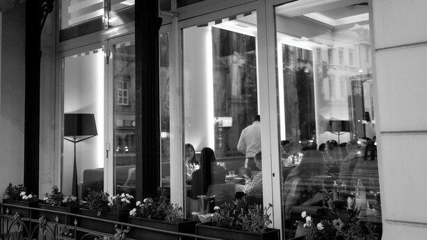 A wine bar with a glass facade and decorative iron railings. - Hotel Waldinger (Osijek)