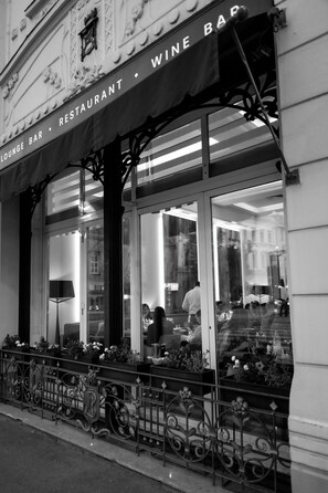 A wine bar with a glass facade and decorative iron railings. - Hotel Waldinger (Osijek)