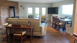A living room with a sofa, chairs, a TV, and a fireplace.
