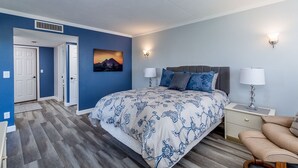 Une chambre à coucher avec un lit, des lampes de chevet, une table de chevet et un tableau au mur.