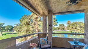 Un balcon avec vue sur un terrain de golf et un étang.