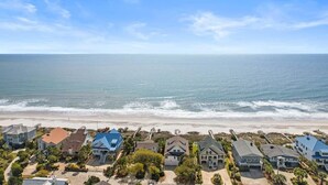 A coastal residential area with houses along the beachfront, featuring a variety of roof styles and colors. - Alive After Five Where Tranquility Meets the Ocean (Pawleys Island)