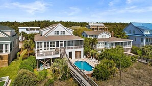 A coastal residential area with multiple houses, a swimming pool, and a wooden deck. - Alive After Five Where Tranquility Meets the Ocean (Pawleys Island)