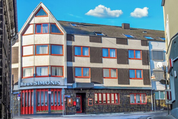 Un edificio de varios pisos con un letrero que dice "Haus SIMONIS" en la planta baja.