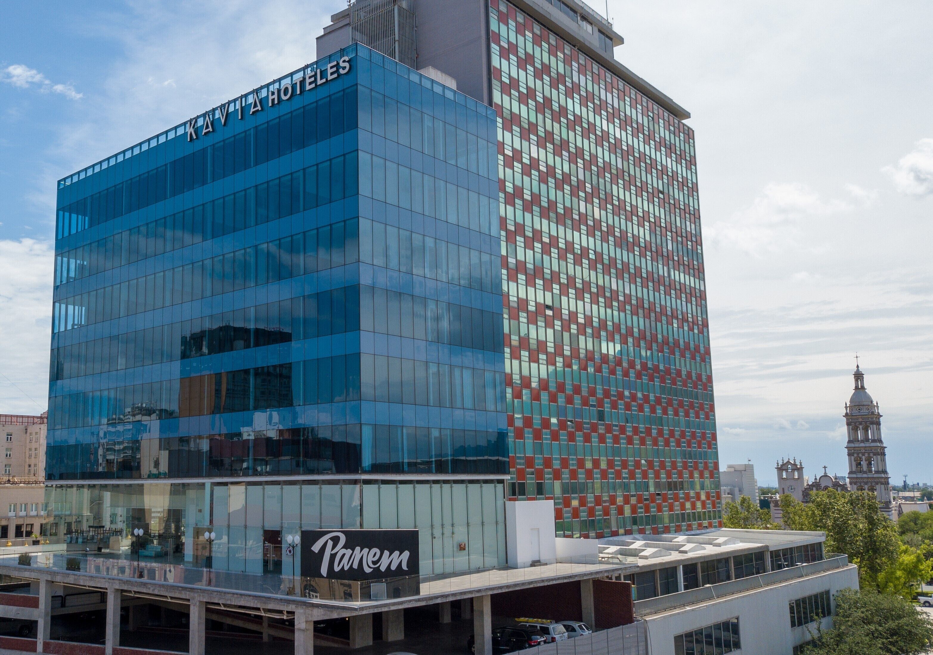 Un moderno edificio de hotel con fachada de vidrio y un cartel que dice "Panem".