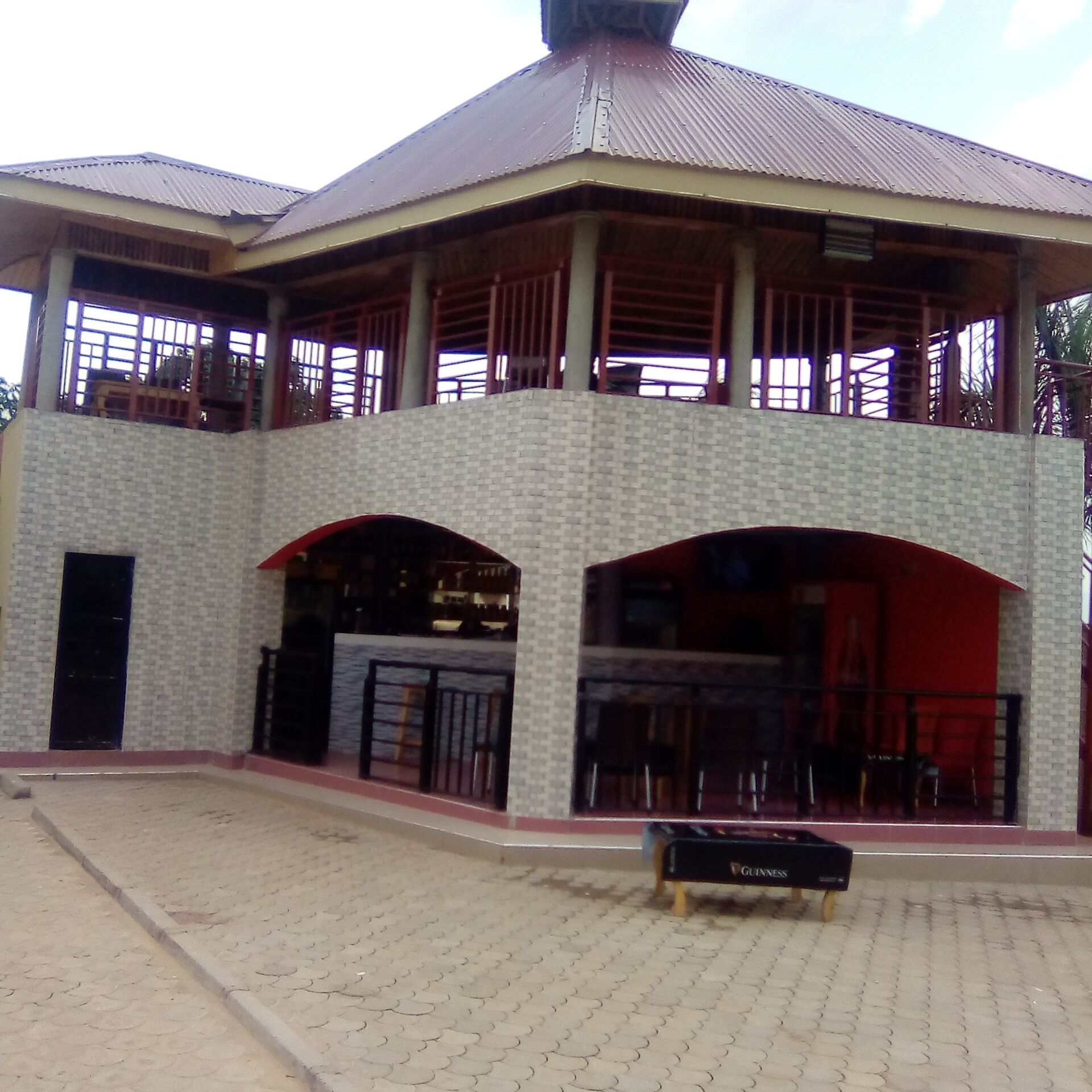A two-story building with a covered patio area and a small outdoor seating space.