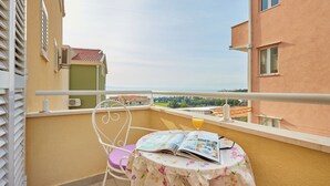 Un balcon avec une table, une chaise et un magazine.