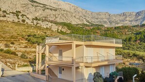 Un immeuble à deux étages doté de balcons, situé dans un paysage montagneux.