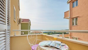 A balcony with a table, a chair, and a magazine. - Apartments Zelic Tucepi  S3 (Tucepi)