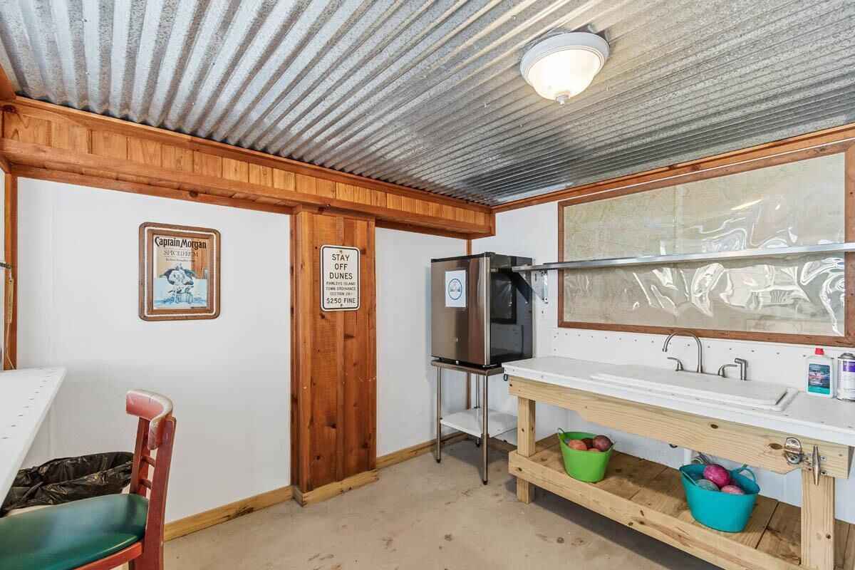A compact kitchen with a stainless steel refrigerator, a sink, and wooden cabinets.