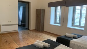 A bedroom with two beds, a wardrobe, and a window. - Hotel Lemi (Mestia)