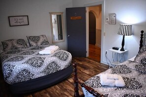 A bedroom with a bed, a bedside table, a lamp, and a mirror.