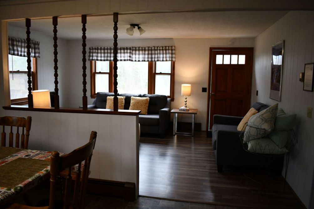 Ein gemütliches Wohnzimmer mit einem Holzesstisch, einer Couch und einem kleinen Beistelltisch.