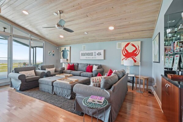 A modern living room with a grey sectional sofa, a wooden ceiling, and a view of the sea. - Lakefront-Marina in back! Get-a-way in New Orleans (New Orleans)