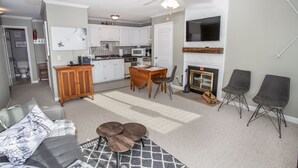 A compact living space with a kitchenette, dining area, and a fireplace. - Ski Condo on Beech Mountain (Beech Mountain)
