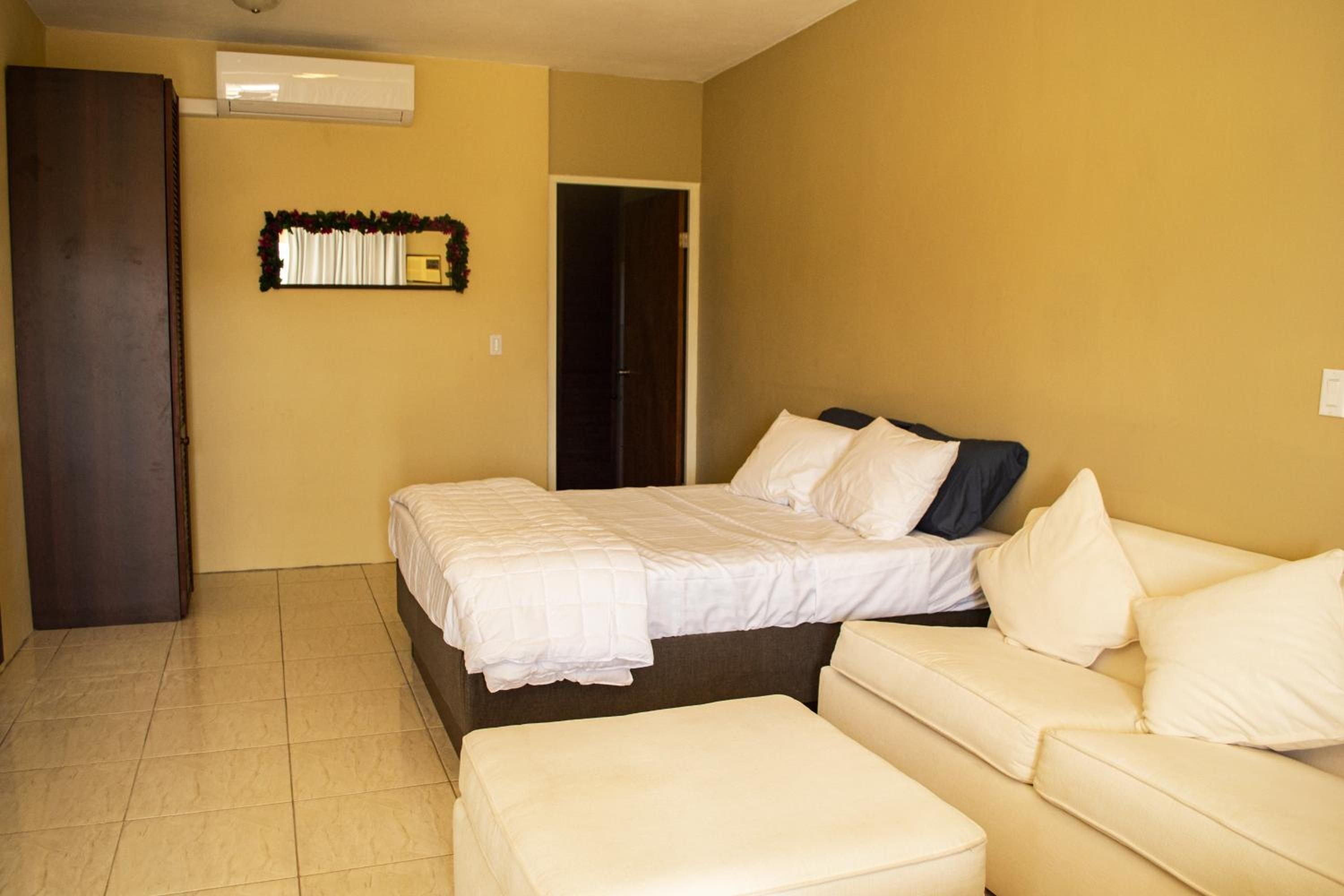 A hotel room with a bed, a sofa, and a small table.