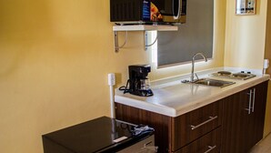 Une cuisine compacte équipée d’un four à micro-ondes, d’une machine à café et d’un petit réfrigérateur.