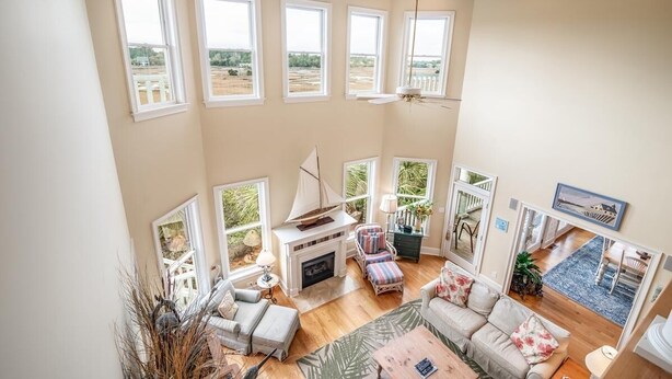 A spacious living area with a fireplace, large windows, and a view of the outdoors.