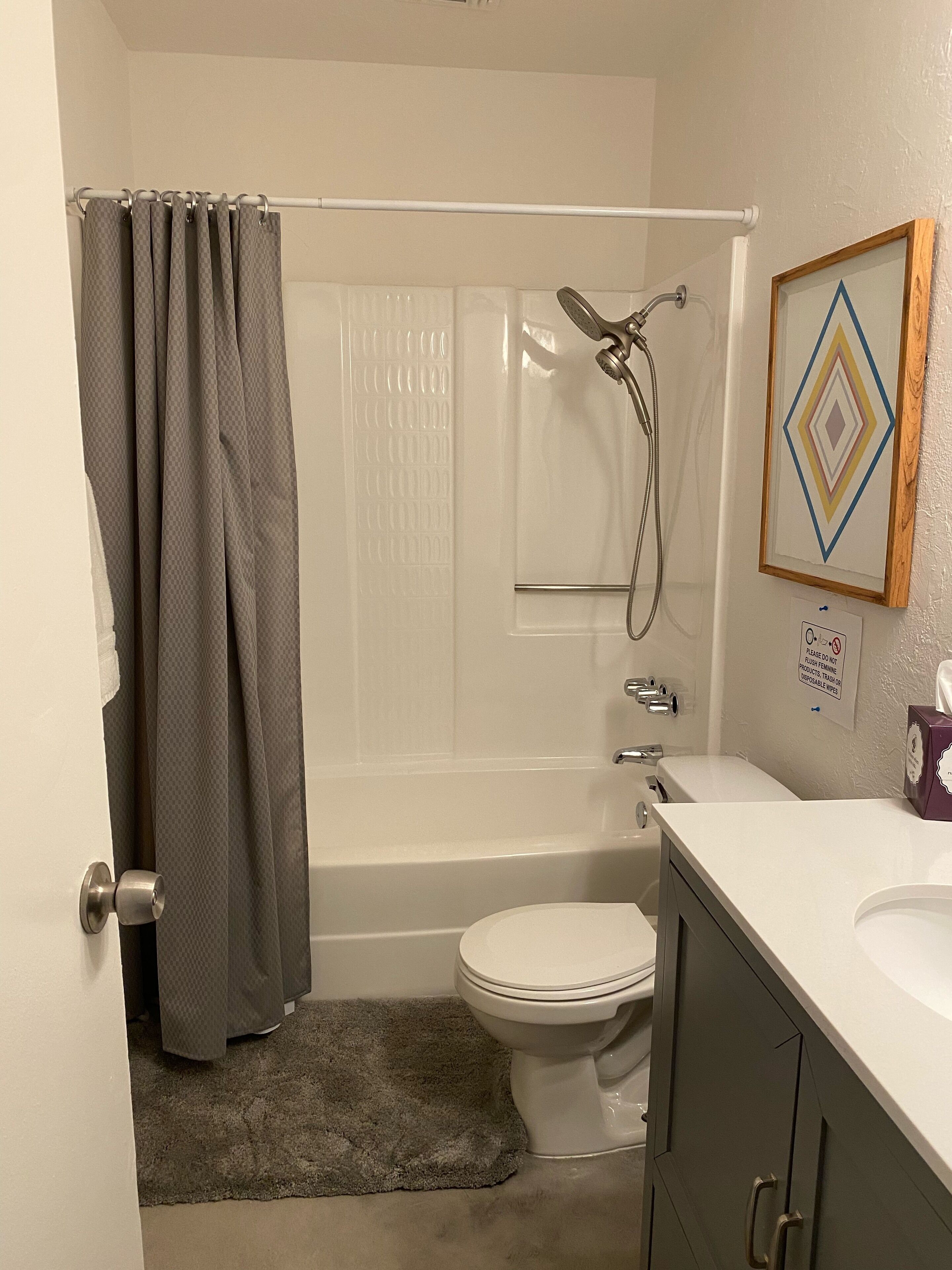 A bathroom with a shower, toilet, and sink.