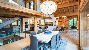 A spacious interior with a dining area, kitchen, and a large staircase. - Chalet Rass: Sublime five bedroom chalet fully equipped (Chamonix)