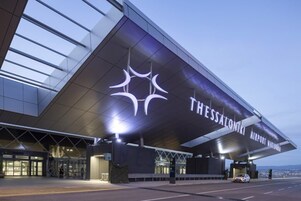 Terminal del Aeropuerto de Salónica con un diseño moderno, destacada estructura de techo y señalización clara.