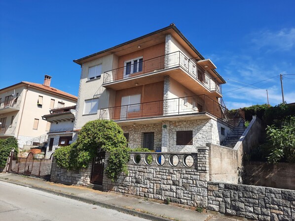 A multi-story residential building with balconies, a stone facade, and a clear blue sky. - Apartment Vicky close to Arena amphitheater and center (PULA)