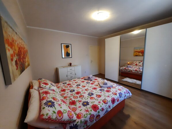Een slaapkamer met een bed, een kaptafel en een spiegel.