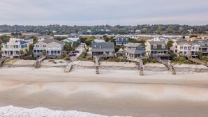 A coastal residential area with beachfront properties, including houses with balconies and a beach access walkway. - Oceanfront Escape with Beach Access (Pawleys Island)