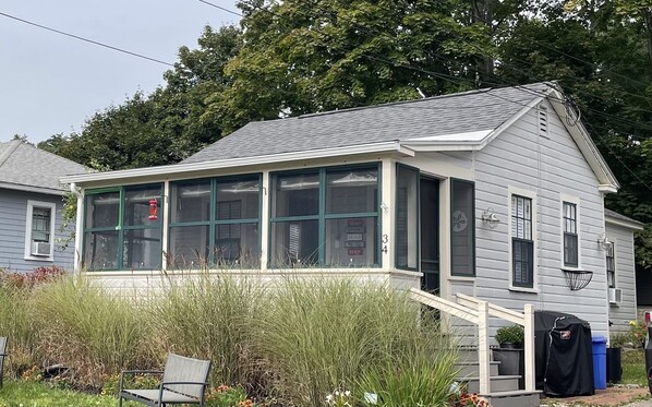 A single-story house with a covered porch and a large windowed front section.