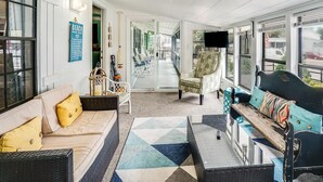 Un salón amplio con sofá, sillones, una mesa de centro y televisor.