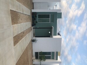 A modern building with a green door, a satellite dish, and a potted plant. - “Casa Toledo 524-A” La ciudadela Ciudad Caucel (Merida)
