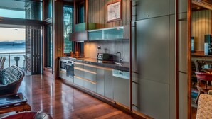 Une cuisine moderne avec vue sur la mer, un plancher en bois et un coin repas offrant également une vue agréable.