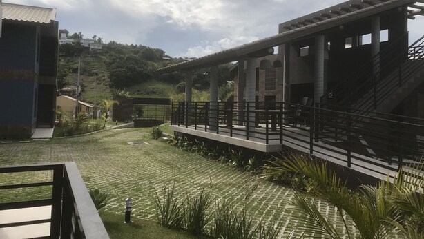 A building with a covered outdoor area, a staircase, and a paved pathway. - House with 2 bedrooms in a condominium. (Praia da Gamboa)