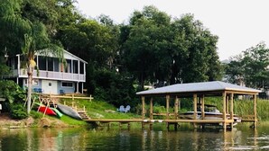 A lakeside property with a house, a dock, and a covered pavilion. - PRIVATE LAKEFRONT + DOCK Bring your boat,  Hot Tub, Kayaks, Paddleboards (Montverde)