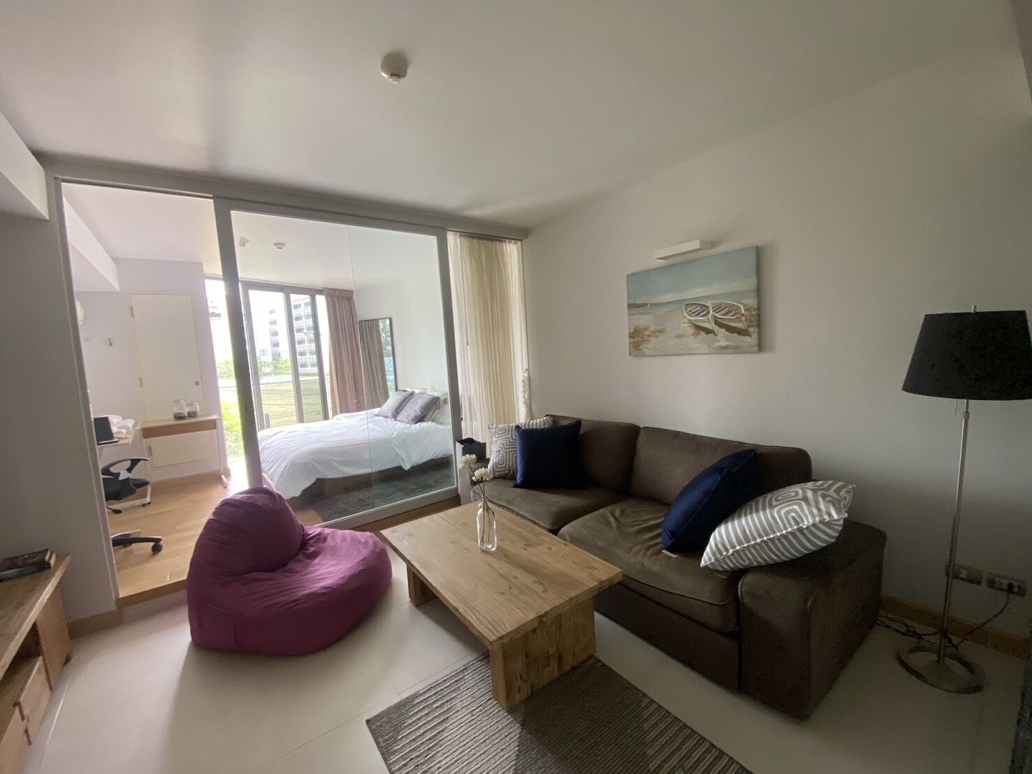 Een moderne woonkamer met een bed, een bank, een salontafel en een stoel.