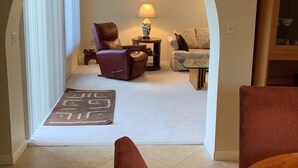 A living room with a fireplace, a sofa, a chair, and a lamp. - Tranquil 3BR, 2BA Condo at Indian Palms - near Coachella (Indio)
